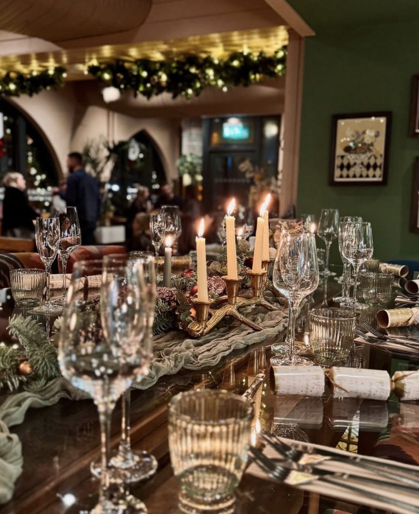 Candlelit Christmas table with crackers and festive greenery at The Granary Bristol