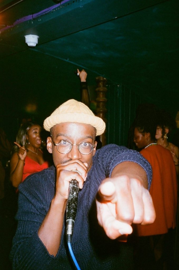 A singer with a microphone pointing towards the crowd in The Granary Club
